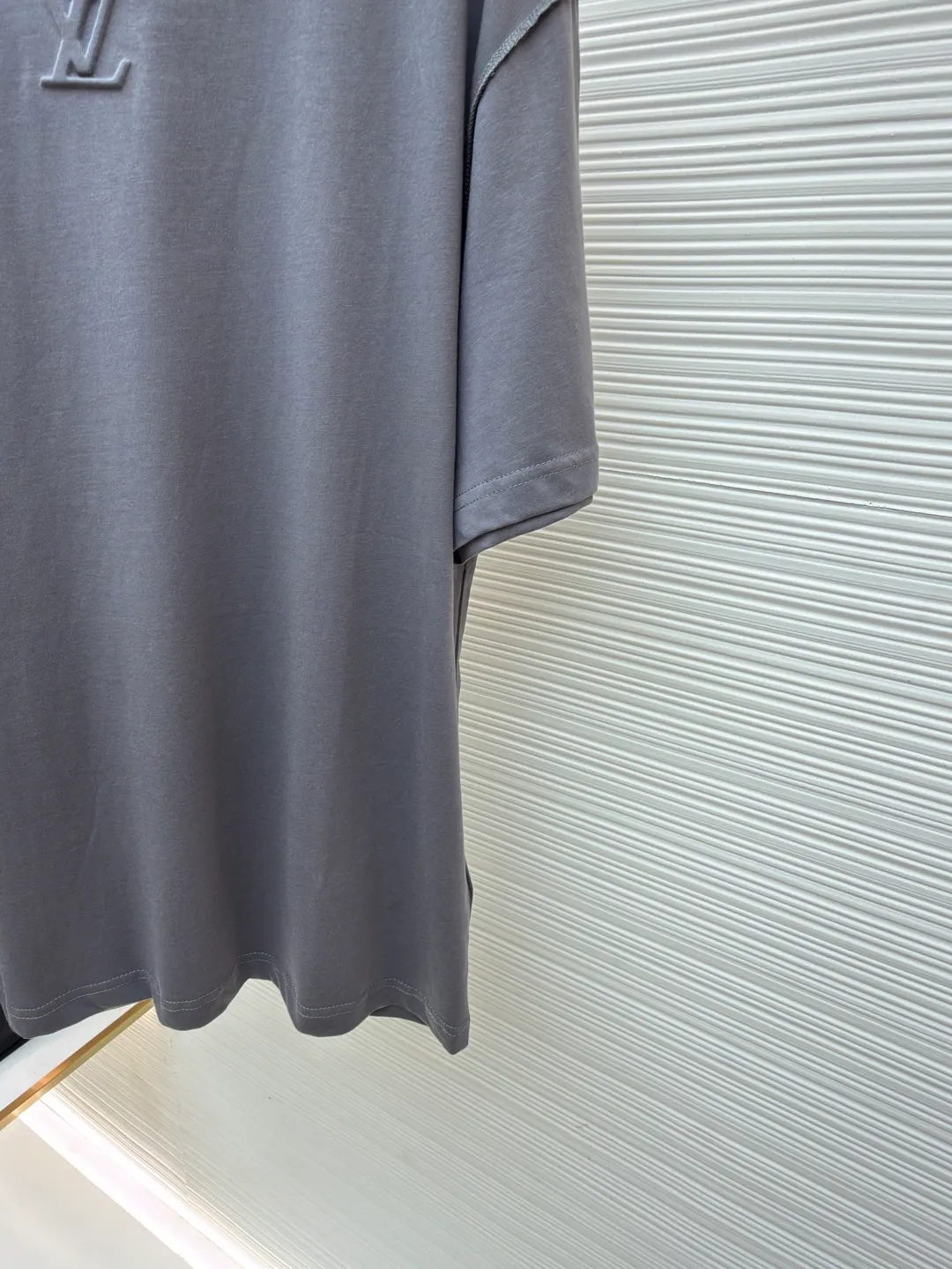 LOUIS VUITTON Concave embossed round neck short sleeves ●Original version: Purchased and developed in 5010 ●Item number: 1681360-A00 ●Fabric: plain knitted fabric ●Technology: embossed embossed production ●Color: gray ●Version: fitted version ●Weight: about 205 grams ●Size: High-count combed cotton yarn eliminates most of the short hairiness through compact spinning process, making the yarn smoother and stronger. The woven fabric structure is extremely dense, flat and soft, with excellent anti-pilling ability and durability, while retaining the natural advantages of pure cotton, which is breathable and skin-friendly. The neckline is made of 32S 1x1 rib with a weight of 300g. The finer yarn count creates a more delicate and tight thread, which provides better elasticity and deformation resistance than ordinary ribs, ensuring that the neckline can still remain stiff after being put on and taken off many times. It contains an innovative process of silicone lining. The concave and convex embossing process is heated and shaped by the upper and lower dies. The rollers press the fabric at a certain temperature, and the three-dimensional hierarchical convex surface is produced through mechanical embossing. This makes the embroidered patterns not only three-dimensional and full, but also uniquely soft and elastic to the touch, which is completely different from traditional stiff embroidery. The support of silicone also ensures that the pattern is not prone to wrinkles and deformation after washing, achieving a combination of visual novelty and process durability. The overall wiring is straight and delicate, the fabric is comfortable and soft, and the color is consistent without color difference. It can be matched with the same style to create a fashionable look and control various occasions. Customized accessories, complete with three standards, same style for men and women!